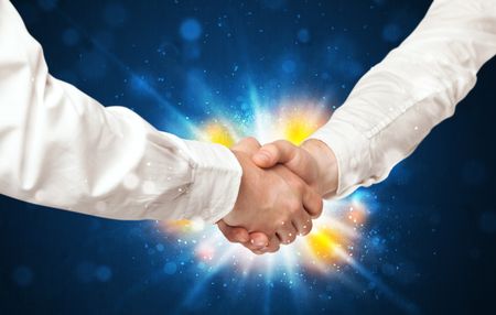 Two business men shaking hands with a successes agreement with explosion 