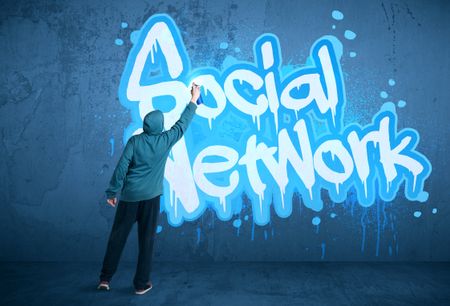 Young urban painter drawing a social network subtitle on the wall