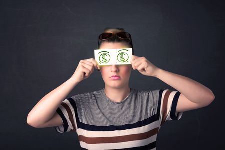 Young girl holding paper with green dollar sign concept