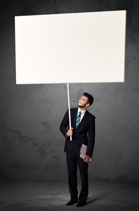 Young businessman holding a blank whiteboard
