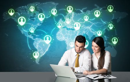 Business couple sitting at table with social media connection symbols on the world map