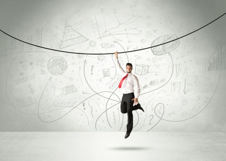 Businessman hanging on a rope with analysis and graphs background 