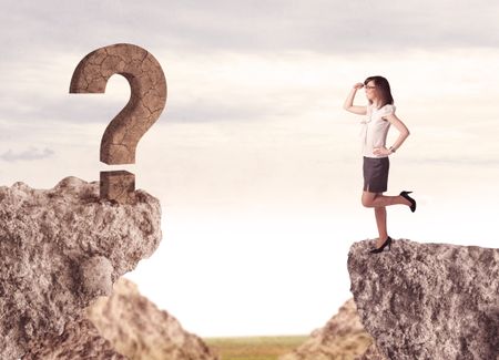 Businesswoman standing on the edge of mountain with a rock question mark on the other side 
