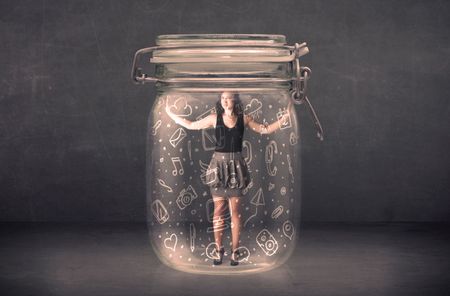 Business woman captured in glass jar with hand drawn media icons concept on background