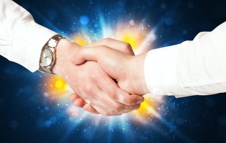Two business men shaking hands with a successes agreement with explosion 