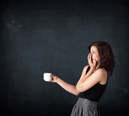 Businesswoman standing and holding a white cup on a black background 