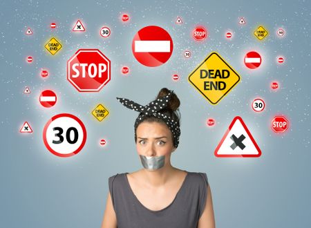 Young woman with taped mouth and traffic signals around her head