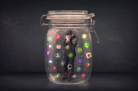 Businessman captured in a glass jar with colourful app icons concept on background