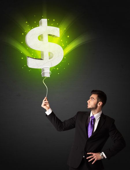 Businessman holding a shining, green dollar sign balloon