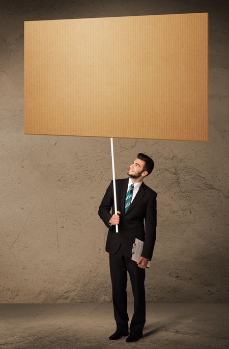 Young businessman holding a blank brown cardboard 