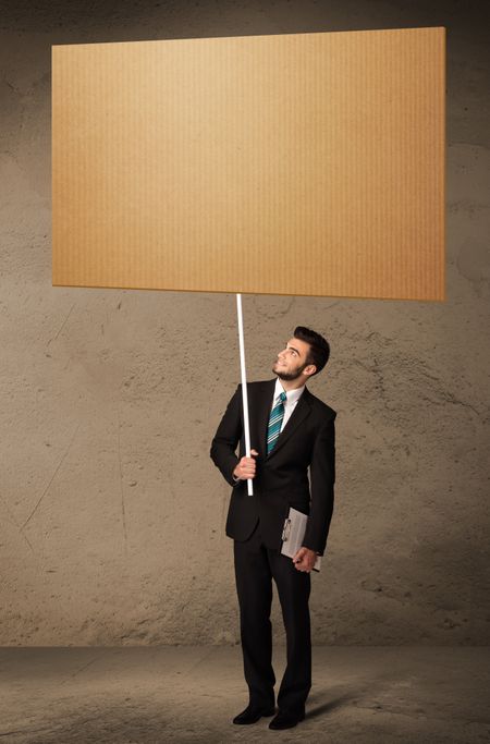 Young businessman holding a blank brown cardboard