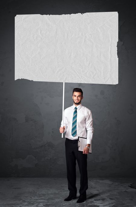 Young businessman holding a big blank booklet paper