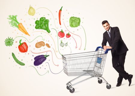 Businessman pushing a shopping cart and healthy vegetables coming out of it 