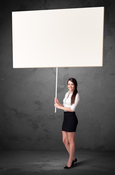 Young businesswoman holding a blank whiteboard 