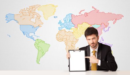 Businessman sitting at white table with colorful world map background