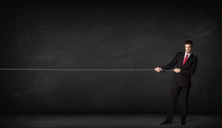 Businessman pulling rope on grey background concept
