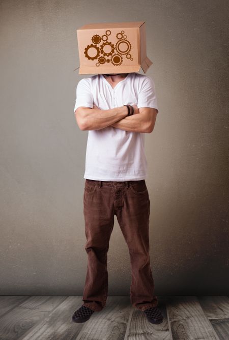 Young man standing and gesturing with a cardboard box on his head with spur wheels