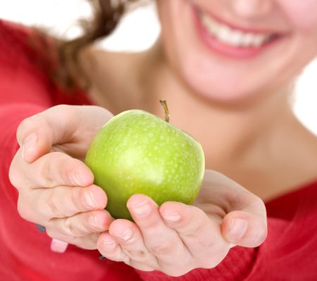 girl holding an apple with her hands while smiling - focus is on apple