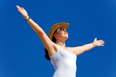 girl with open arms enjoying her freedom over a blue sky