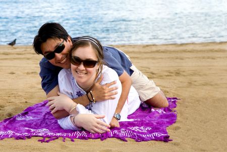 beautiful couple in love at the beach hugging each other