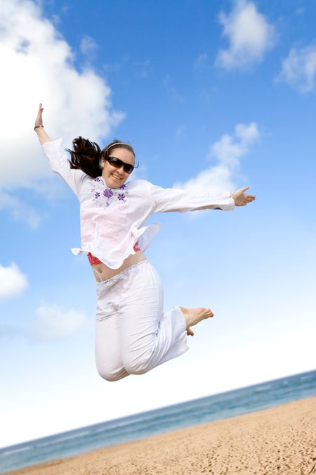 girl jumping on the beach on a sunny day