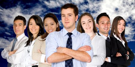 confident business man and his business team - group formed of people from all over the world over a nice blue sky