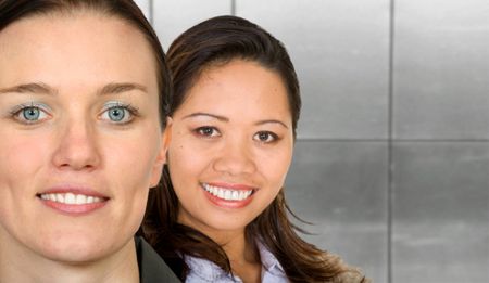 asian-european female partnership with an office background