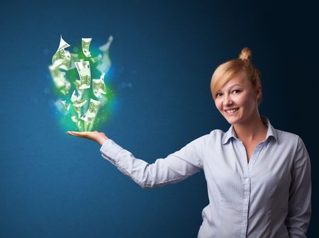 Young businesswoman holding glowing paper moneys in her hand