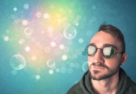 Young man with sunglasses and bokeh colourful lights concept