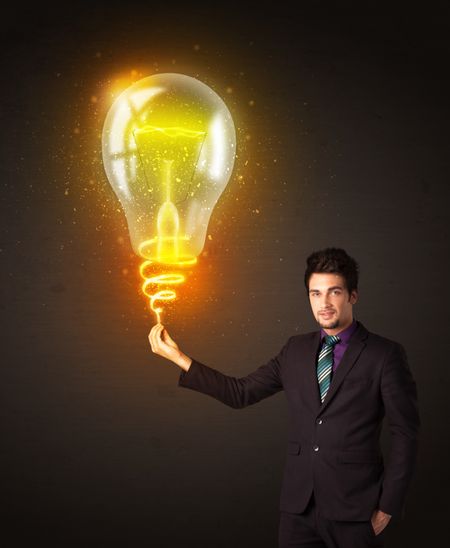 Businessman holding a shining idea bulb