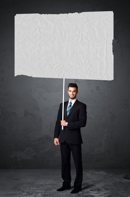 Young businessman holding a big blank booklet paper