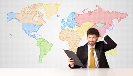 Businessman sitting at white table with colorful world map background