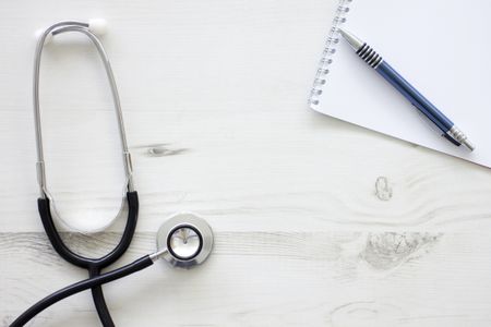 Still life of doctors medical stethoscope on a wooden surface