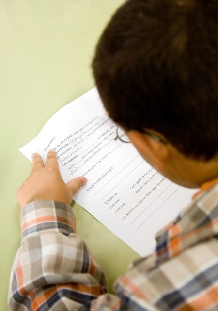 little 8 year old boy answering a generic exam paper