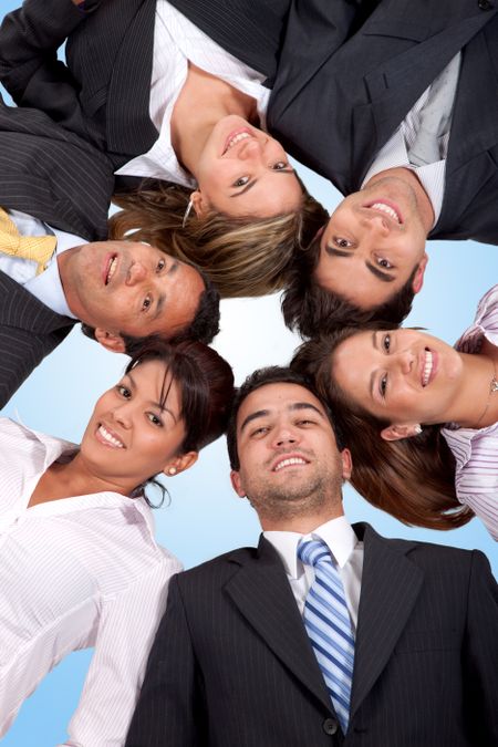 business team with heads together on the floor isolated