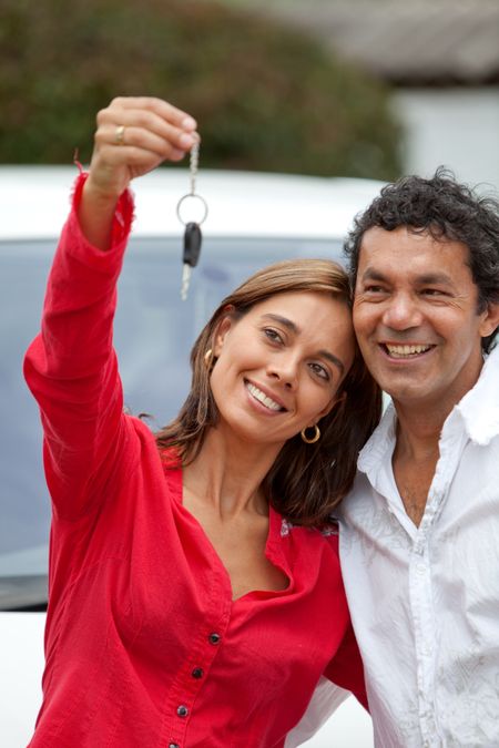 Couple holding up the keys of their brand new car