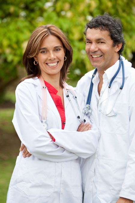couple of doctors standing outdoors smiling