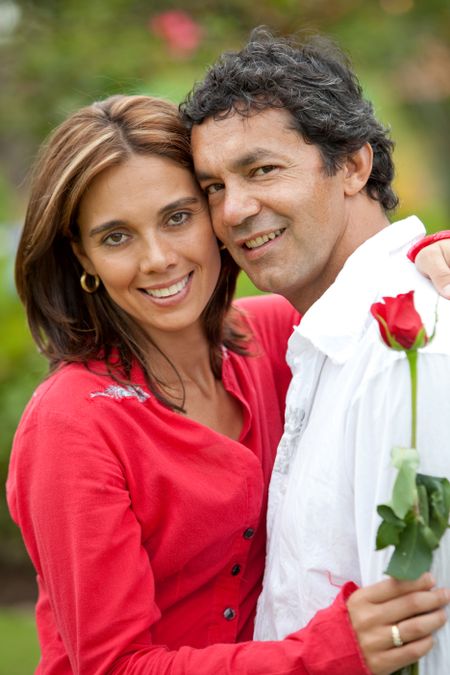 couple in love standing outdoors with a rose