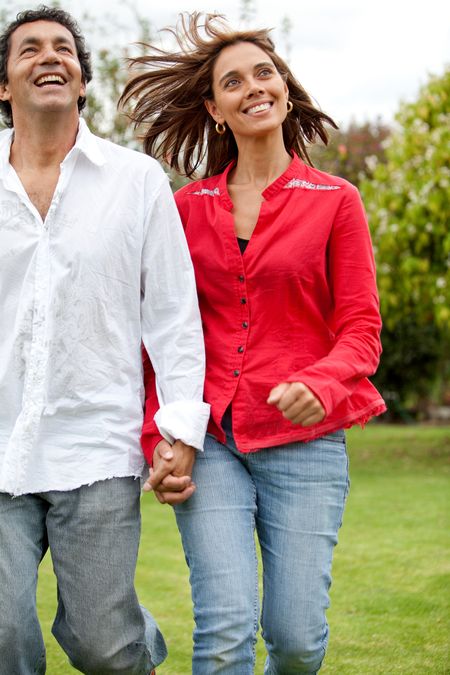 happy couple running outdoors outside their home