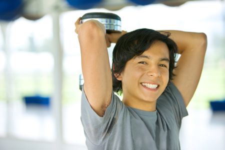 Gym man holding free weights behind his head