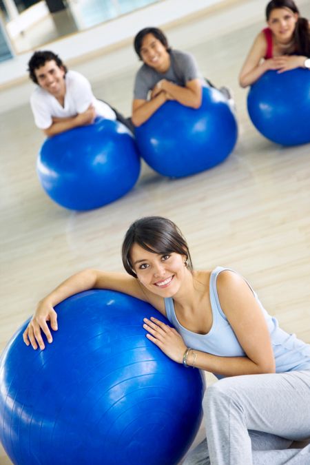 beautiful female portrait at the gym smiling leaning on a pilates ball