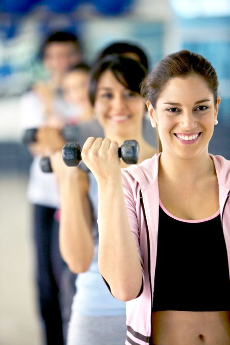 woman holding free weights at the gym