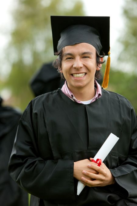 graduation man portrait smiling and looking happy outdoors