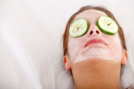 Woman having a cucumber facial mask