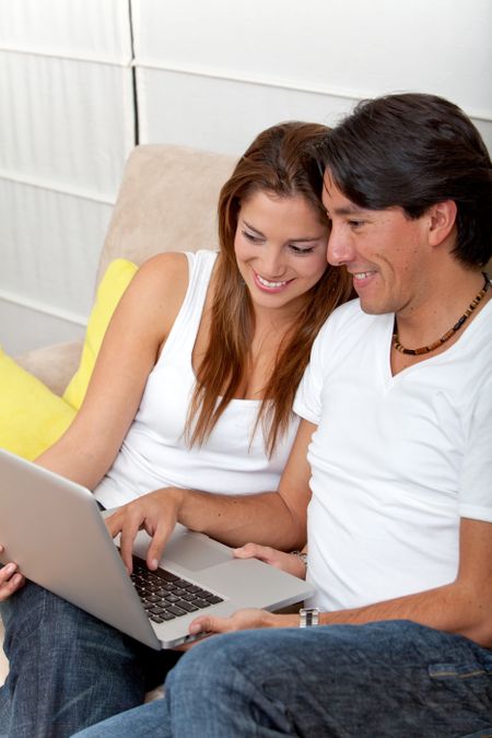 Beautiful couple using a laptop from home