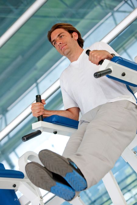 Man lifting his legs at a machine at the gym