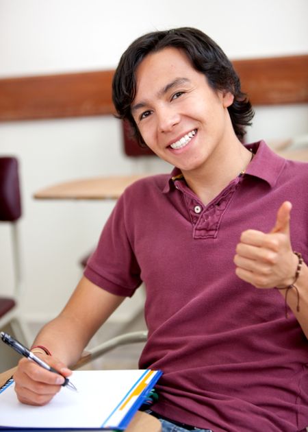 College student in a classroom with thumbs up