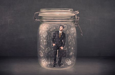 Business man captured in glass jar with hand drawn media icons concept on background
