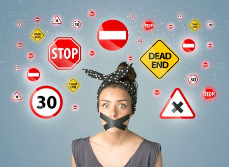 Young woman with taped mouth and traffic signals around her head