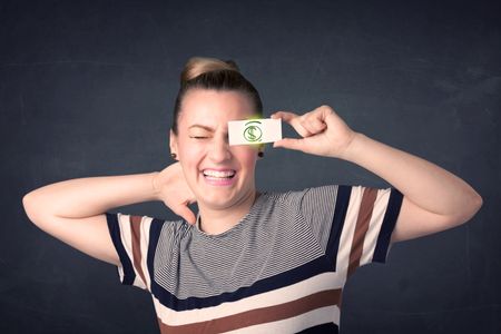 Young girl holding paper with green dollar sign concept